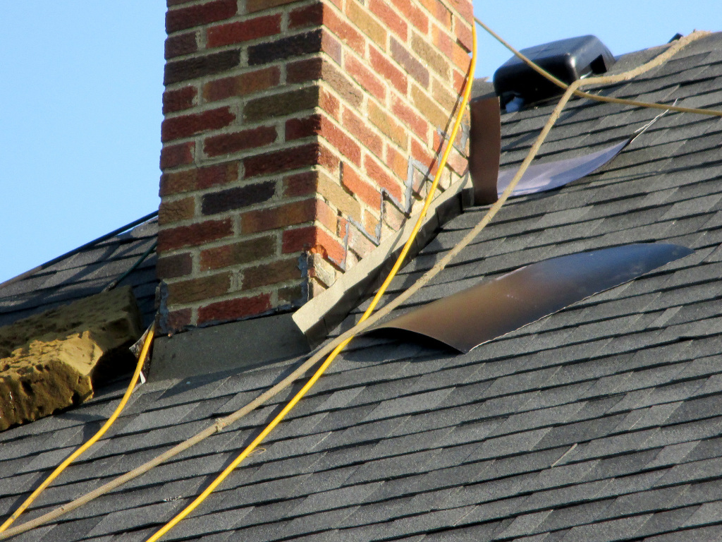 The chimney is in the process of flashing as the roofing contractors install the new roof.