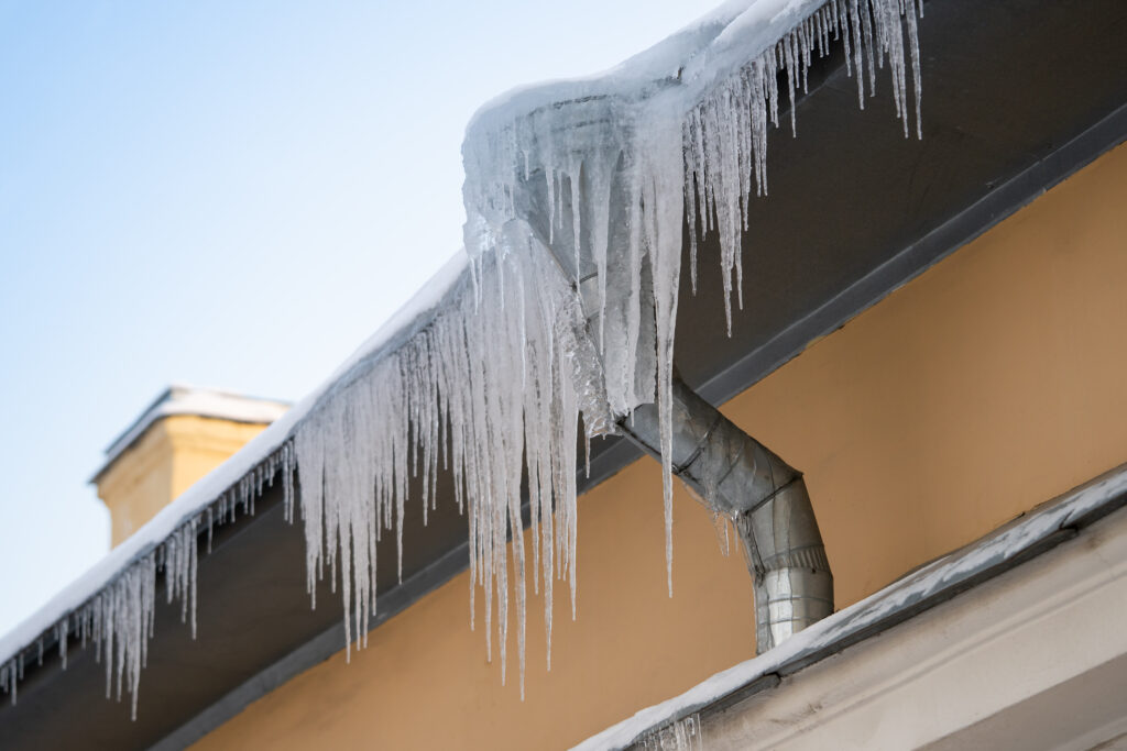 Frozen ice from gutters needing maintenance to protect roof in the winter.